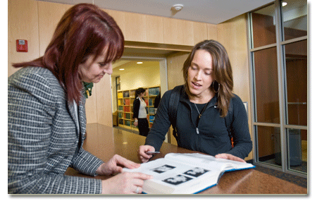 Student receiving assistance at the library circulation desk.