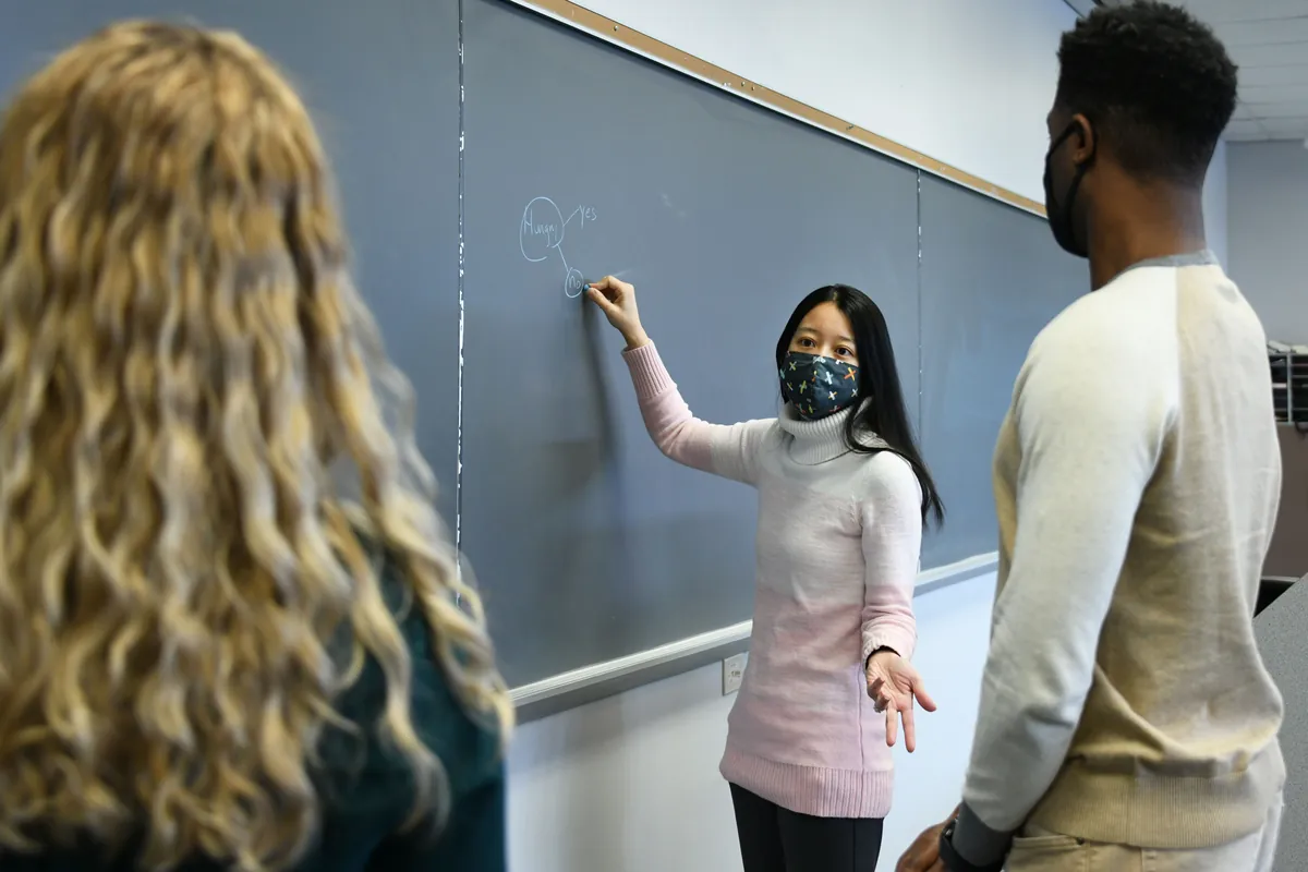 Doctor of Health Professions Education student Helen Halley writes on a chalk board with registered dietitian students at Logan University