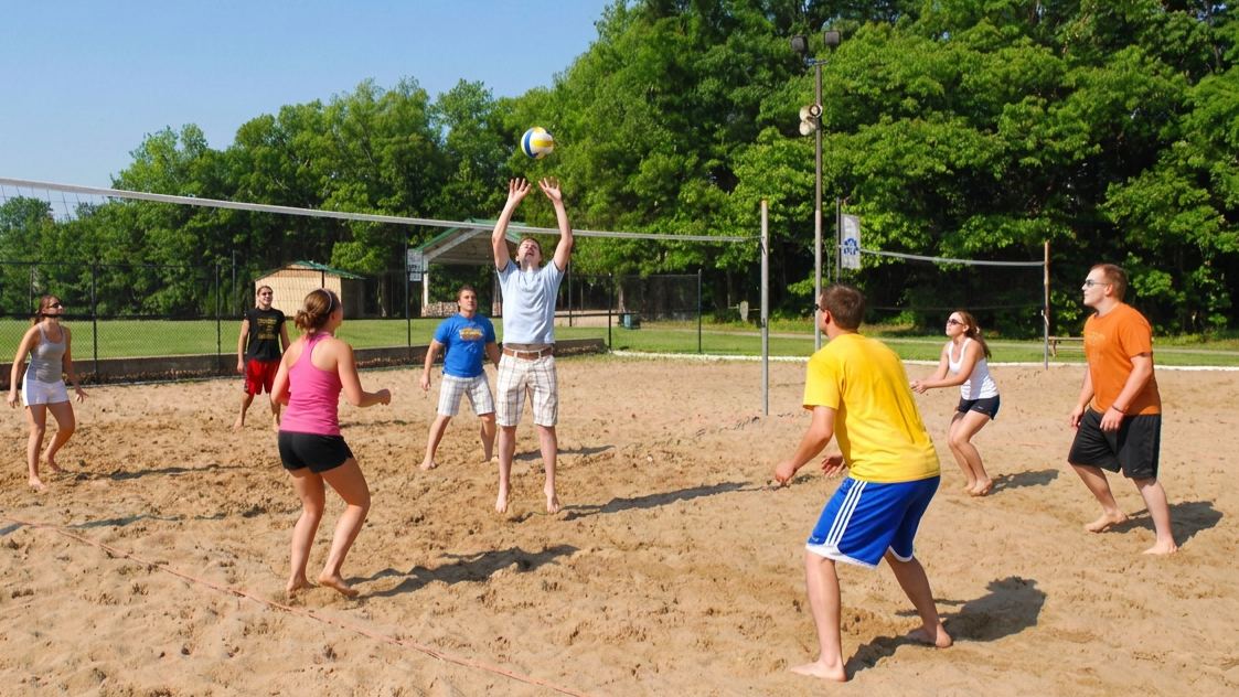 Students playing sand volleyball on the courts at Logan University