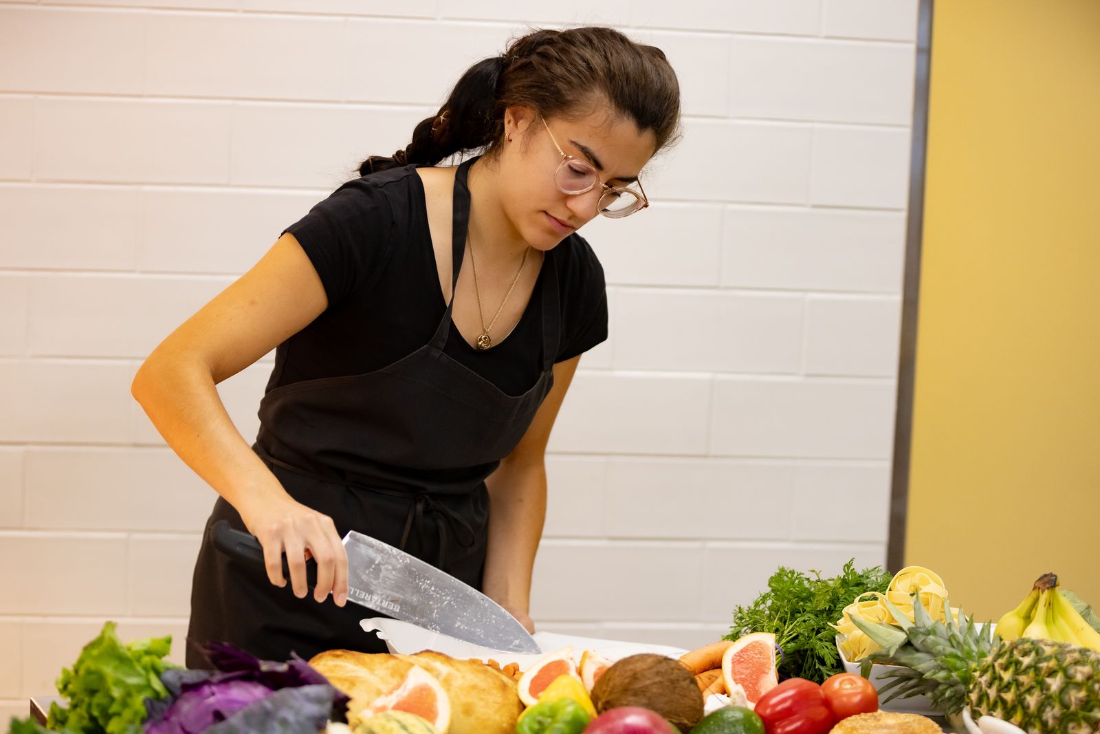A student prepares food in Logan's teaching kitchen