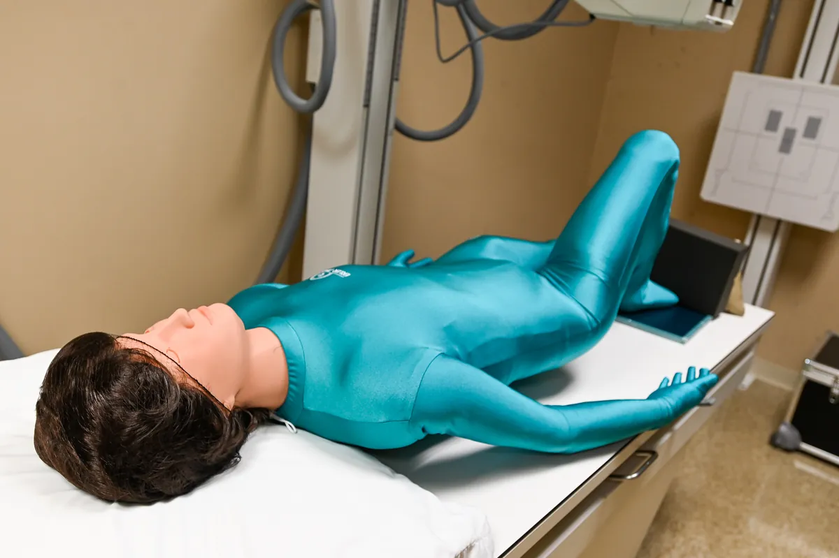 A full-body radiology phantom lies on a table in a laboratory