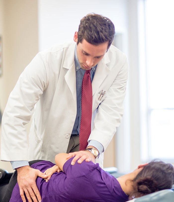 Logan chiropractic intern treating a patient in a Logan health center