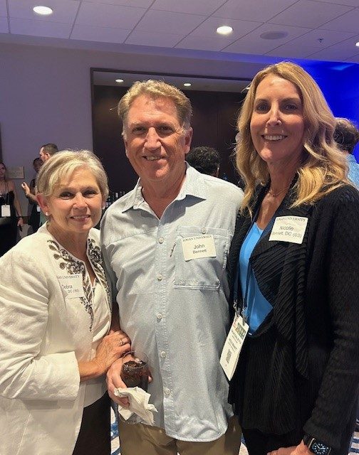 Three Logan University alumni together at an alumni reception