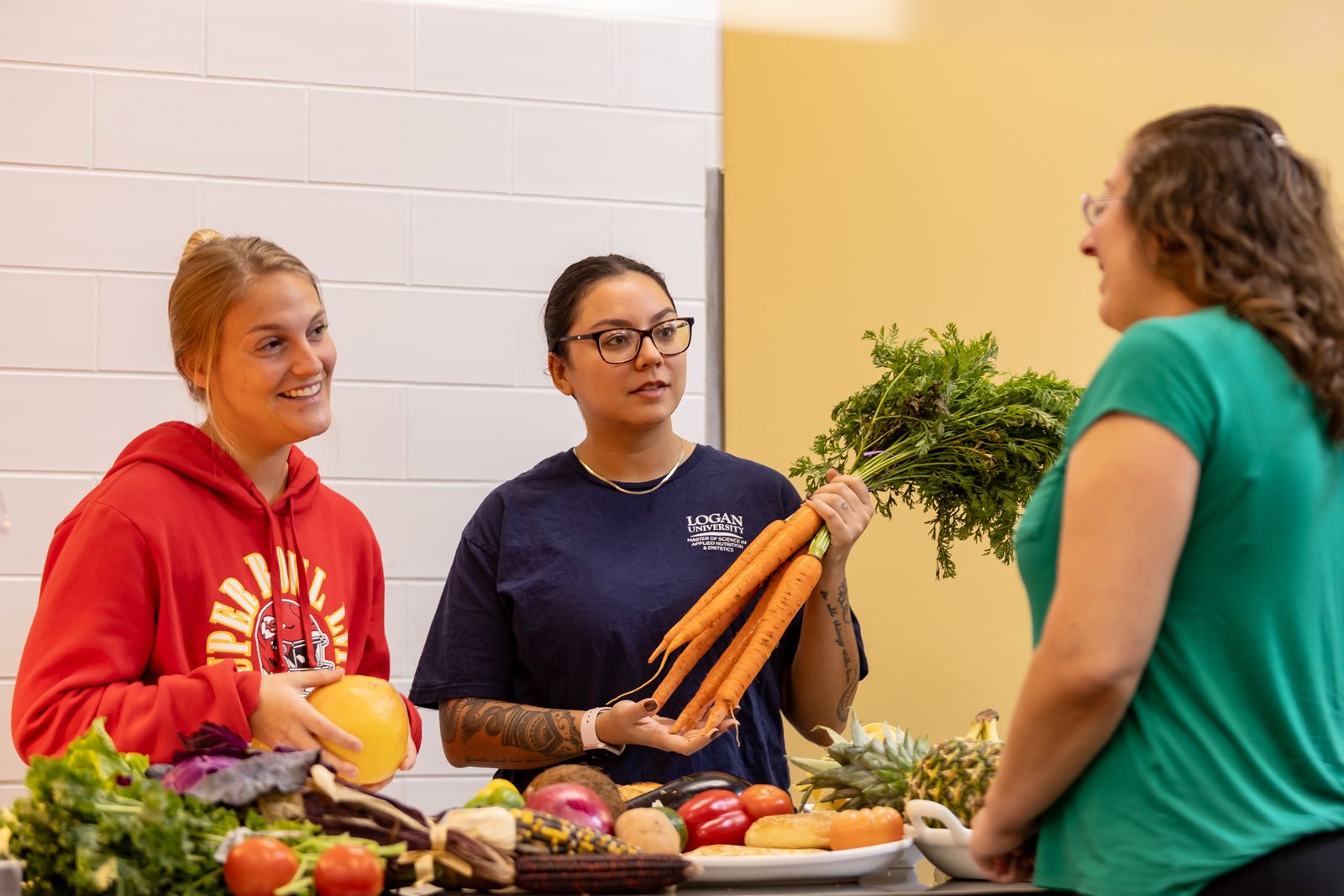 Nutrition students and an instructor with fresh produce in Logan's teaching kitchen