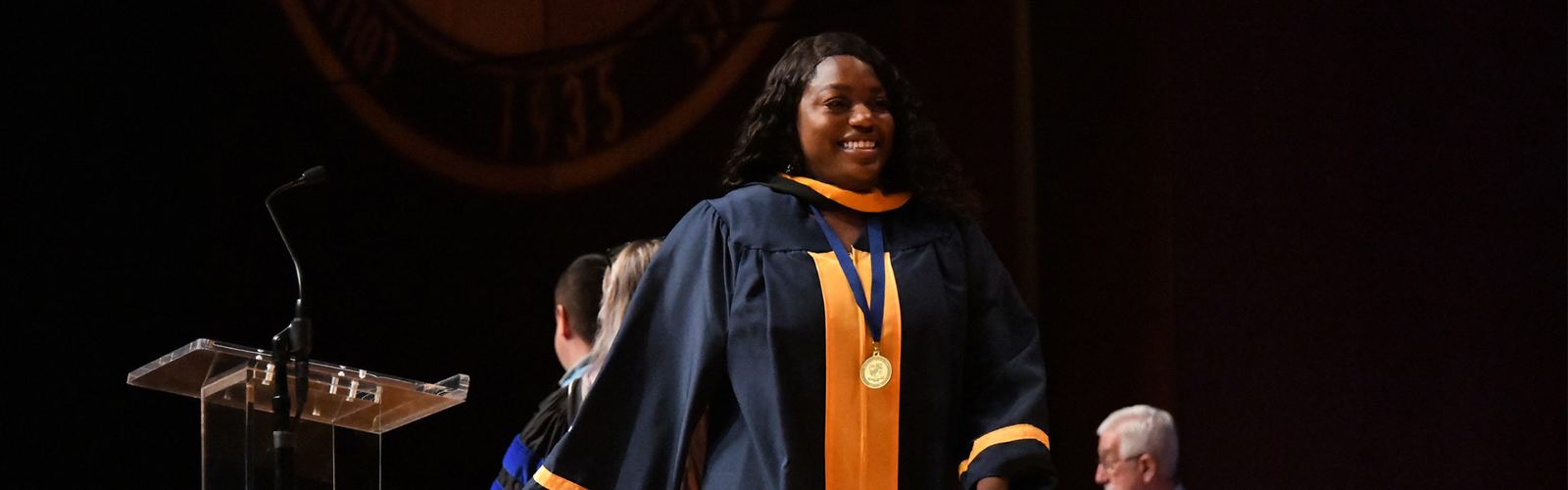 A Logan University graduate crossing the stage at commencement