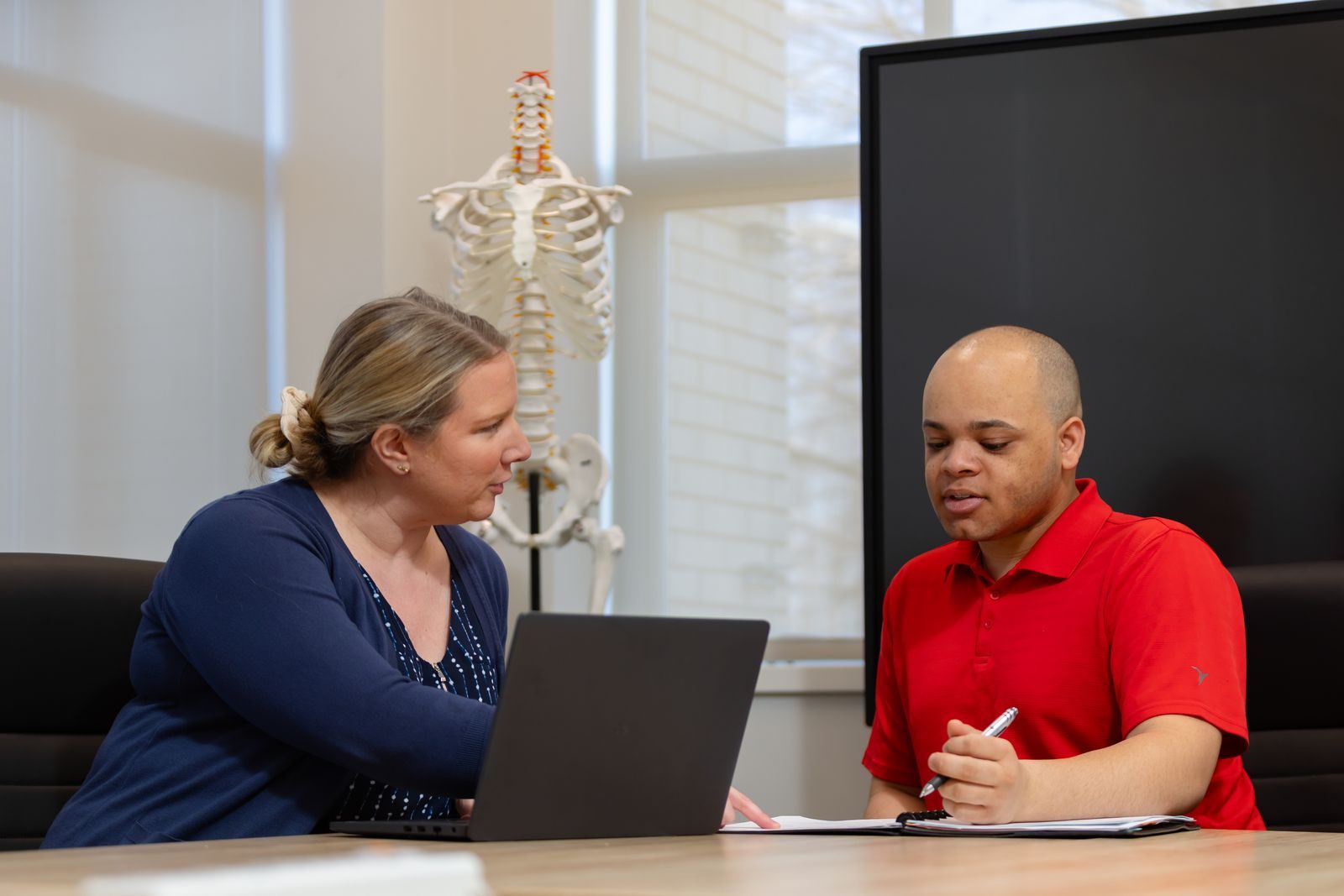 Logan advisor reviews transfer credits on a laptop with a prospective student taking notes