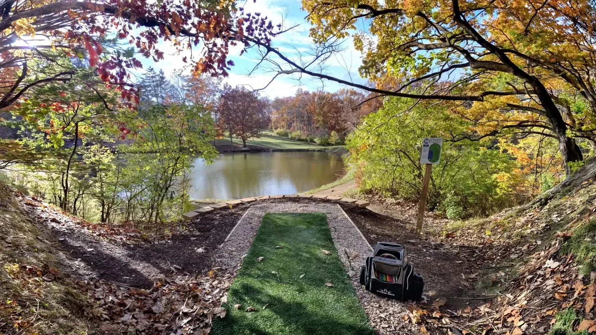 Disc golf tee pad overlooking the lake on Logan University's championship course in autumn