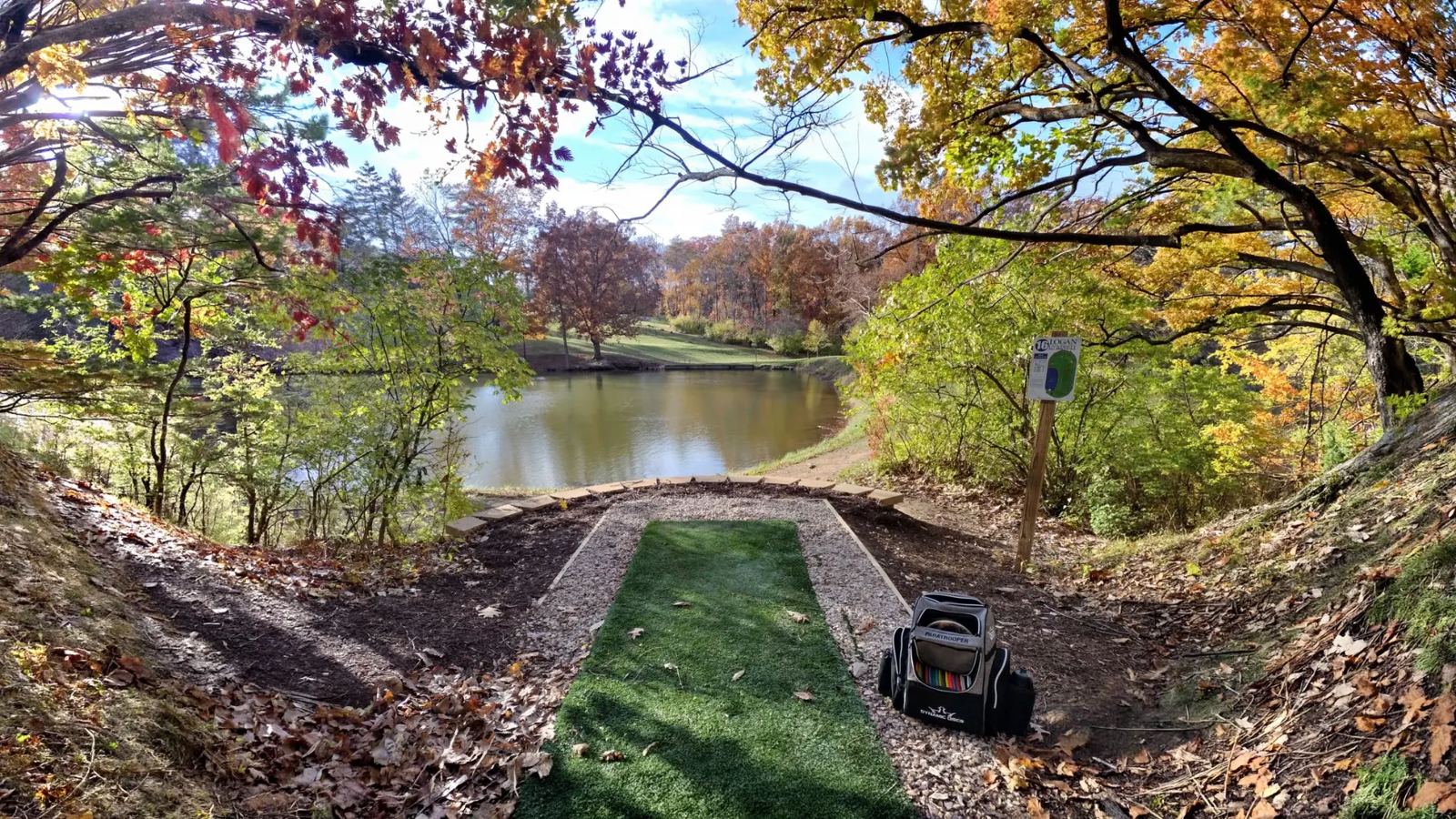 Disc golf tee pad overlooking the lake on Logan University's championship course in autumn