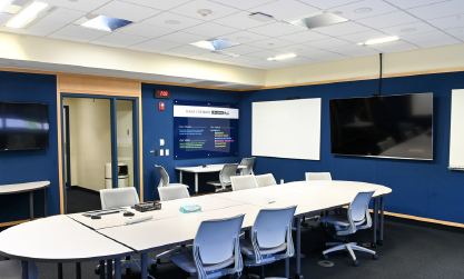 Logan University's Idea Room set with a conference table, seating and wall-mounted displays