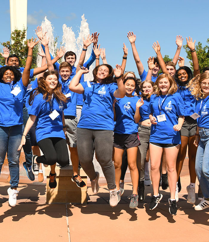 ACES students jumping for a photo outside.