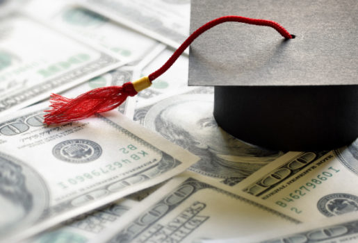 Graduation cap on top of money.