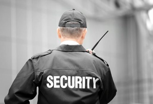 Security guard talking into walkie talkie.