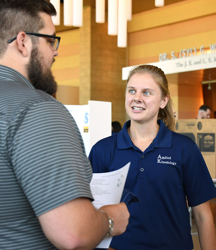 Female club member talking to another student in the Purser Center.