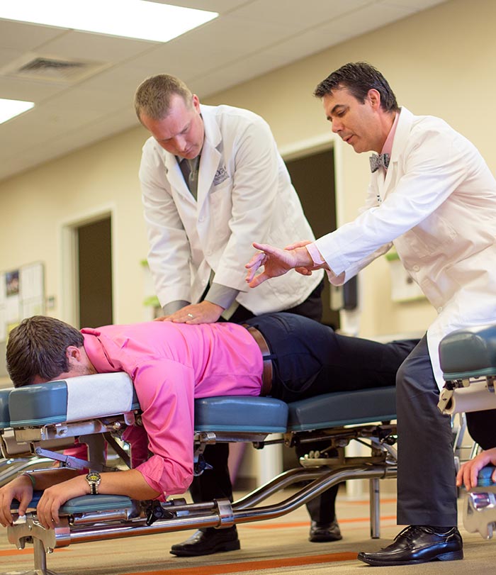 hand-on-grid-large Instructor teaching how to adjust patient.