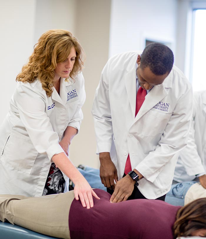 Instructor working with student on patient.
