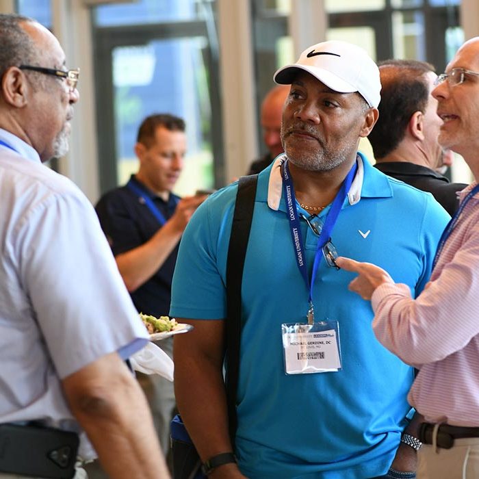Three men talking at the Purser Center.