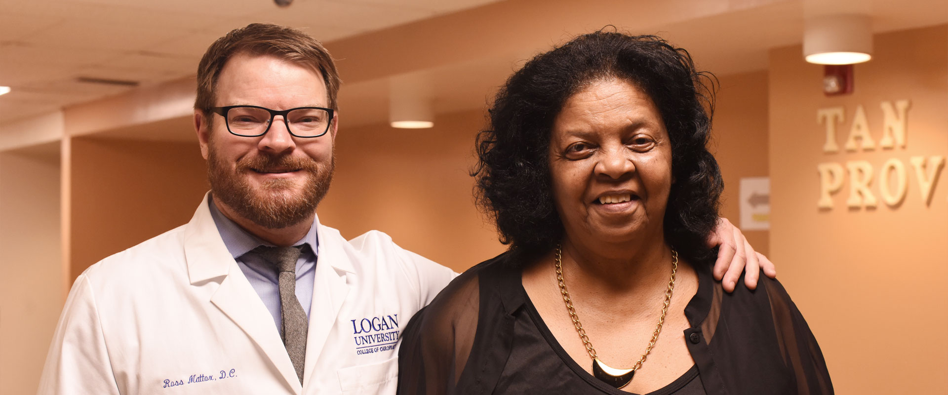 Student smiling with patient at Health Center.