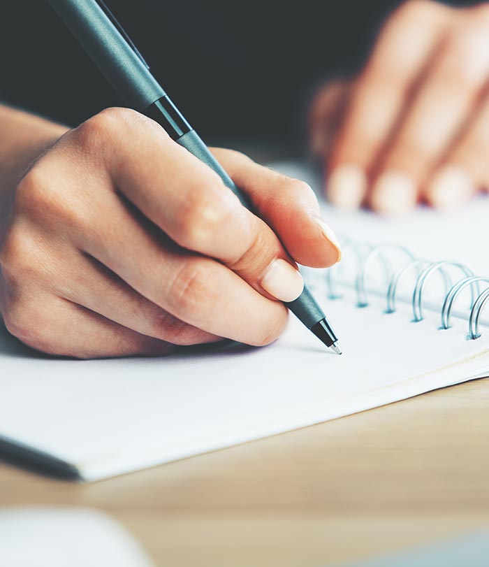 Close up of woman writing in her notebook.