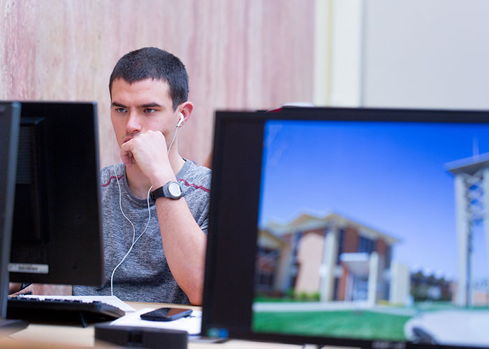 health-informatics-grid-small Male student working on computer.