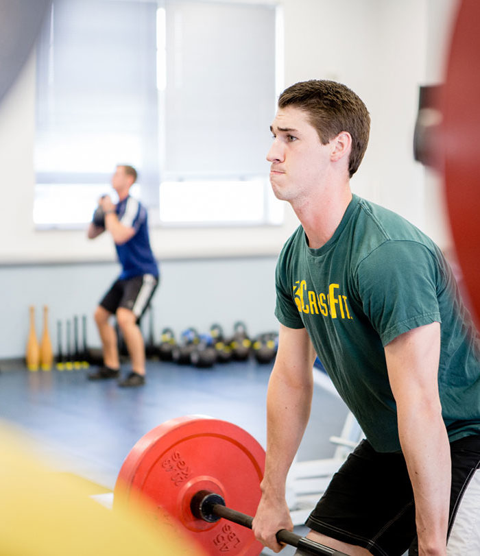 Male student lifting weights in the Wellness Center.