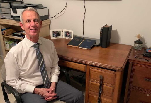 Dr. Filson sits at his desk, which belonged to Dr. Logan