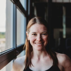 Woman smiles near window