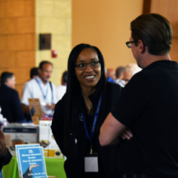 A woman and a man enjoy a conversation at Logan University Symposium